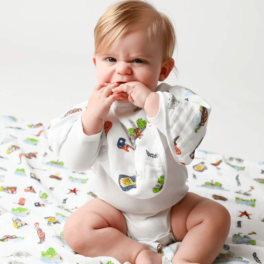 Austin-themed baby gift set with muslin swaddle blanket and burp cloth, featuring Texas icons and landmarks.