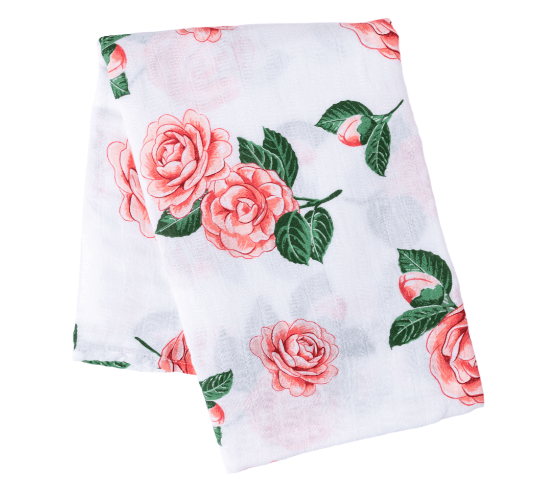 Camelia baby muslin swaddle blanket and burp cloth set with floral design, neatly folded on a white background.