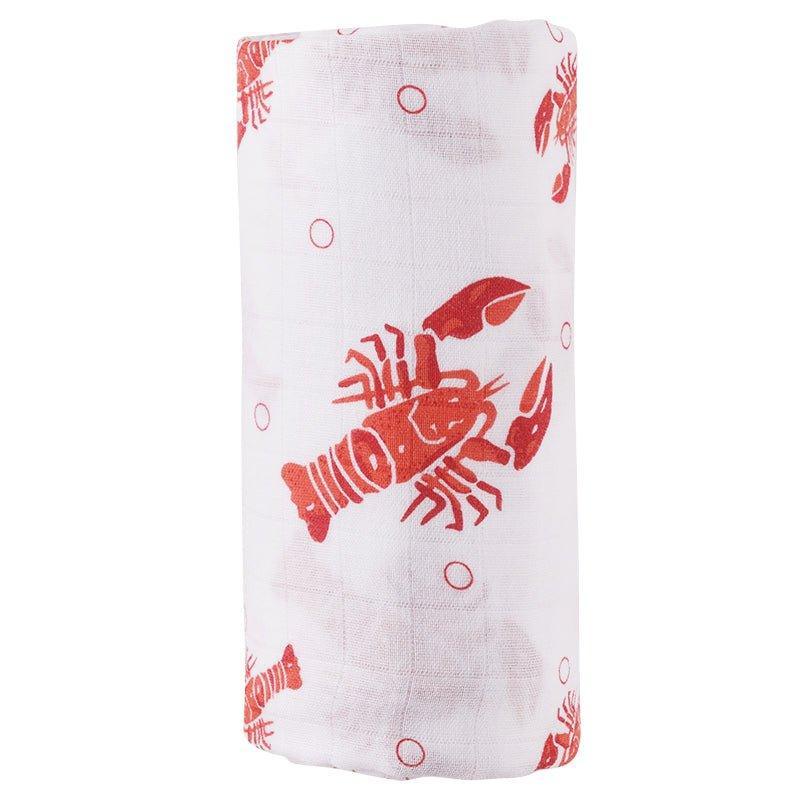 White muslin baby swaddle blanket with playful blue and green fish pattern, folded neatly on a white background.