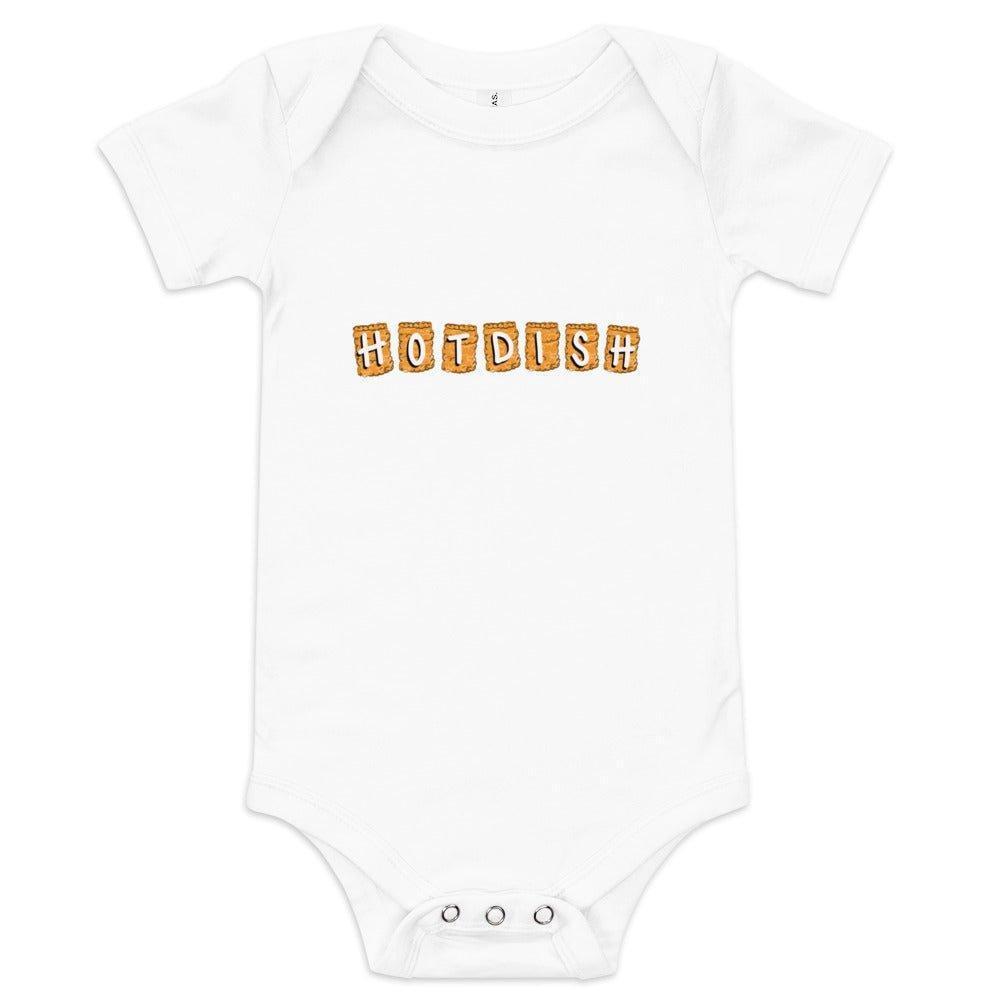 White baby onesie with "Hotdish" in bold red letters, with each letter set askew on casserole dish graphic, on a plain background.