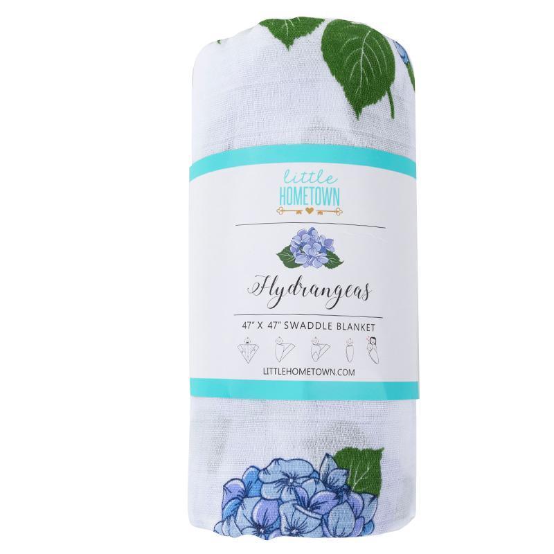 Soft muslin baby swaddle blanket with delicate hydrangea print in pastel blues and greens, folded neatly.