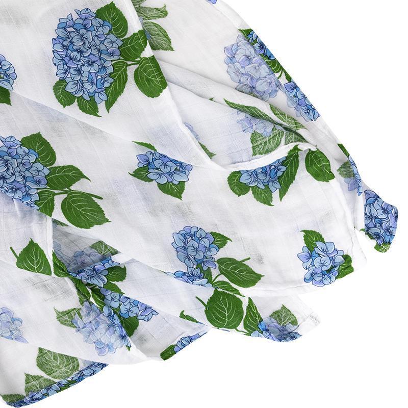 Soft muslin baby swaddle blanket with delicate hydrangea print in pastel blues and greens, folded neatly.