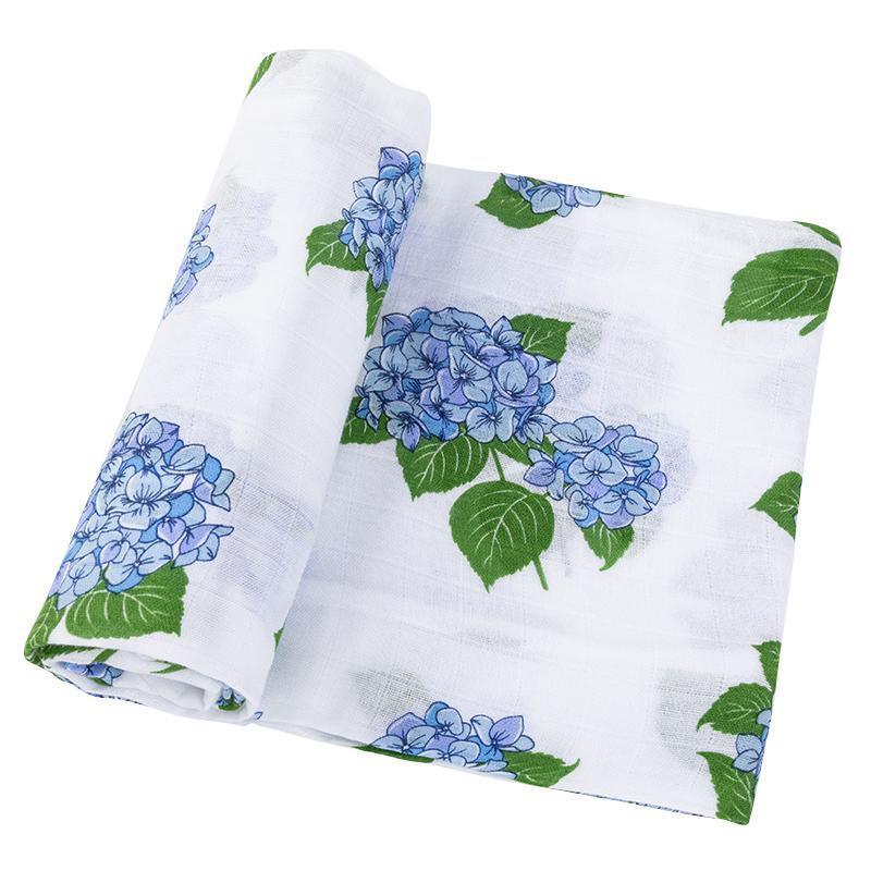 White muslin swaddle blanket with delicate blue and pink hydrangea print, folded neatly on a white background.