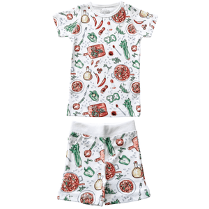 Toddler wearing colorful Jambalaya-themed pajamas with shrimp, sausage, and rice illustrations on a white background.