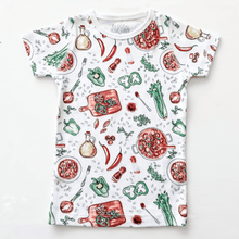 Load image into Gallery viewer, Toddler wearing colorful Jambalaya-themed pajamas with shrimp, sausage, and rice illustrations on a white background.
