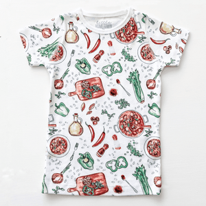 Toddler wearing colorful Jambalaya-themed pajamas with shrimp, sausage, and rice illustrations on a white background.