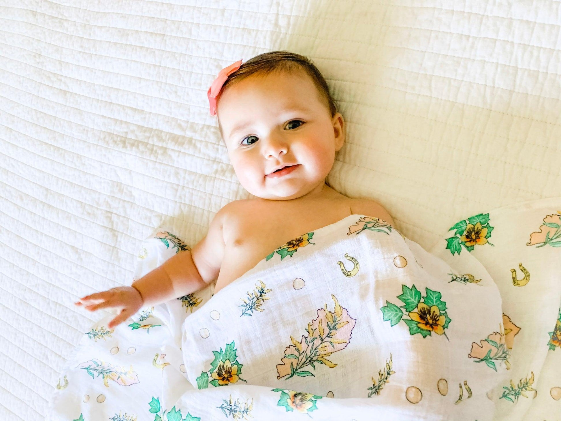 Soft muslin swaddle blanket with a delicate floral pattern in pastel colors, featuring "Kentucky Baby" text.