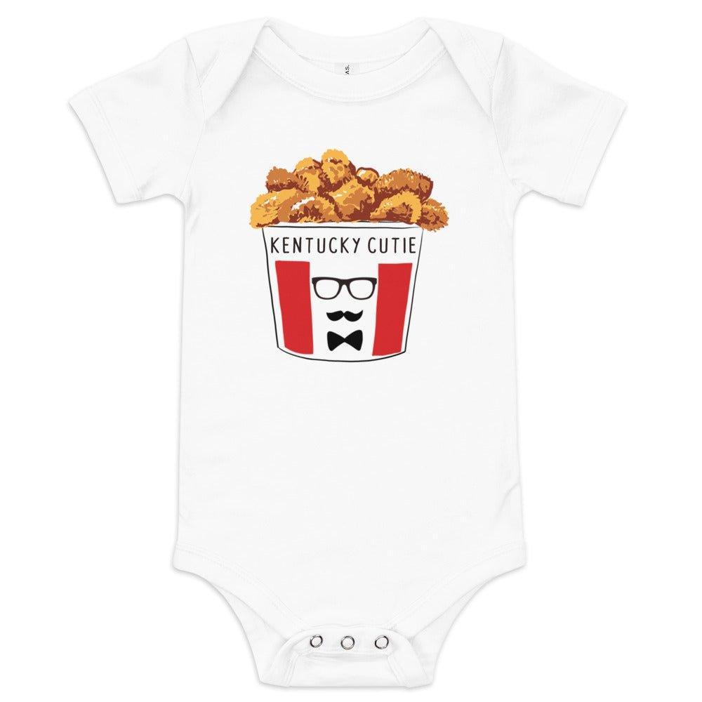 A white baby onesie with "Kentucky Fried" text and a red and white bucket of chicken graphic, sitting on a white background.
