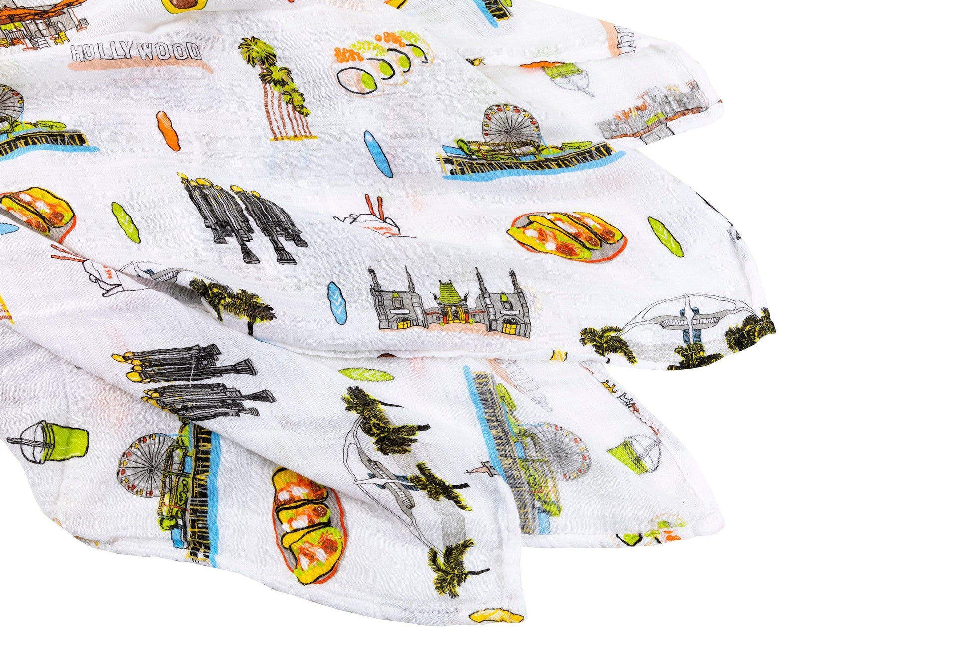 White muslin swaddle blanket with "Los Angeles" text and iconic city landmarks in soft pastel colors.