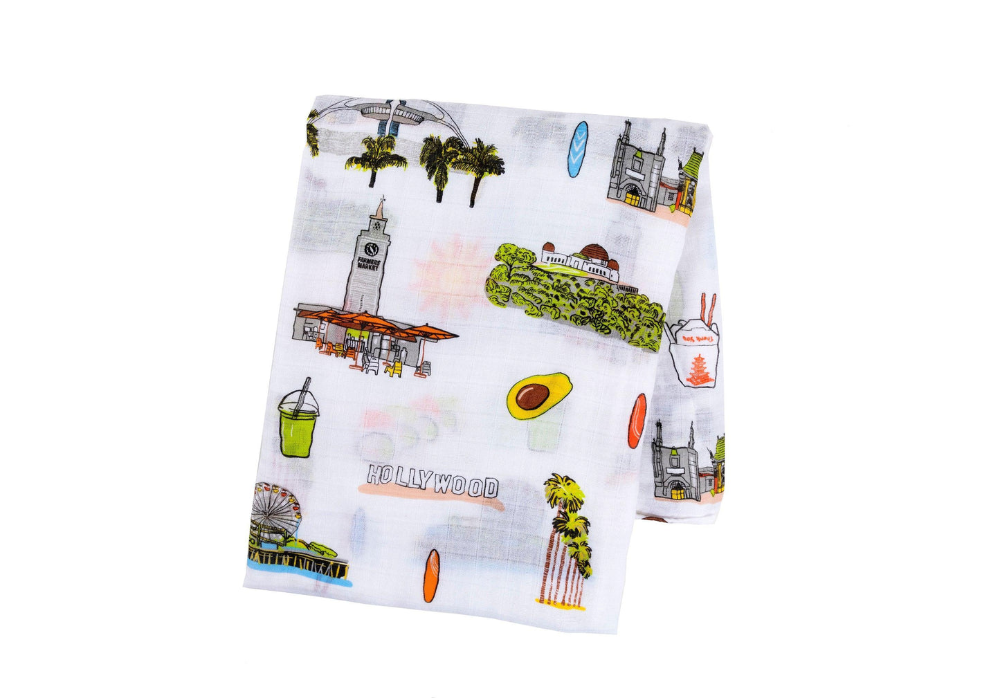 White muslin swaddle blanket with "Los Angeles" text and iconic city landmarks in soft pastel colors.