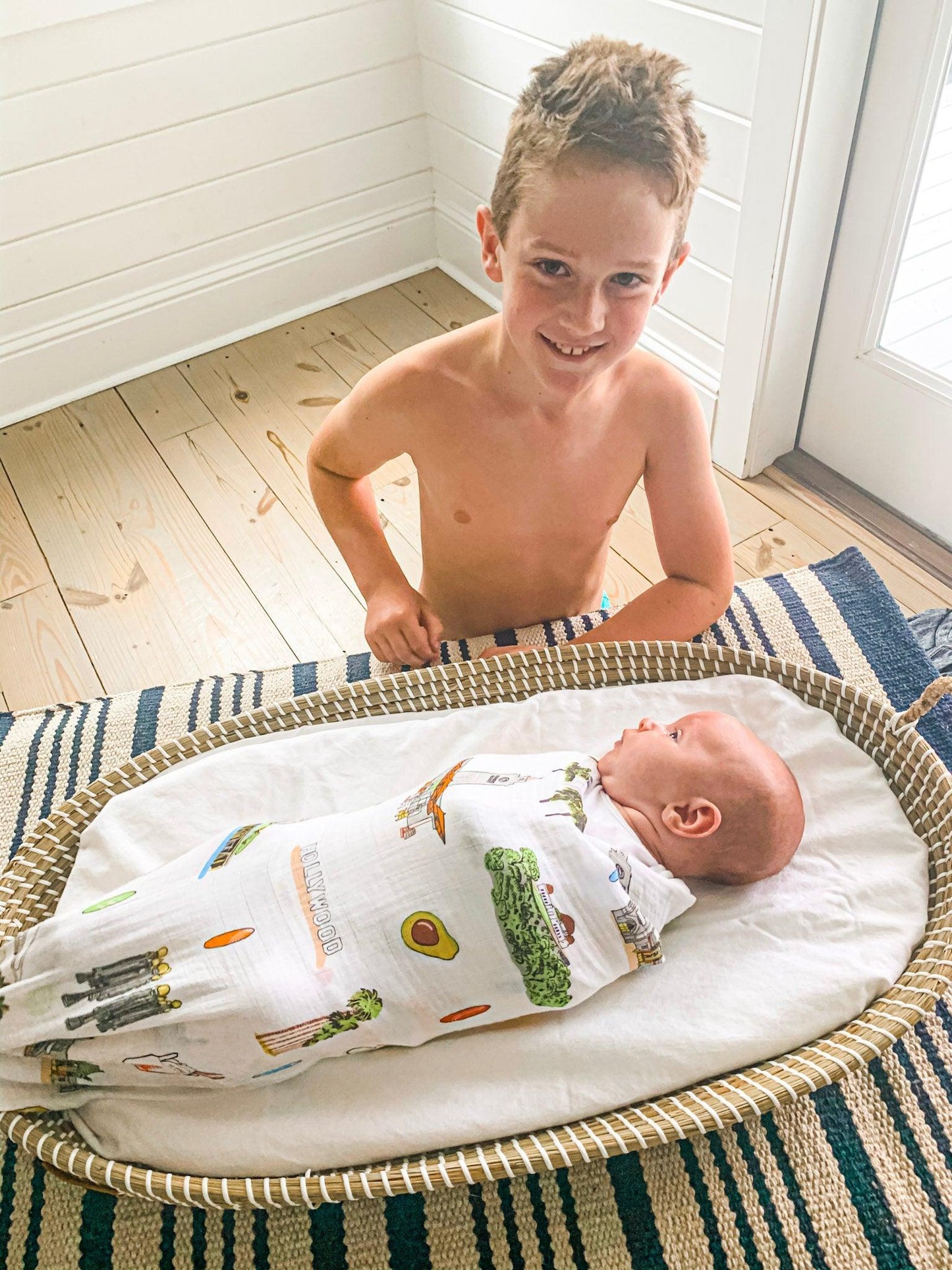 Los Angeles-themed baby muslin swaddle blanket with iconic landmarks and palm trees in soft pastel colors.