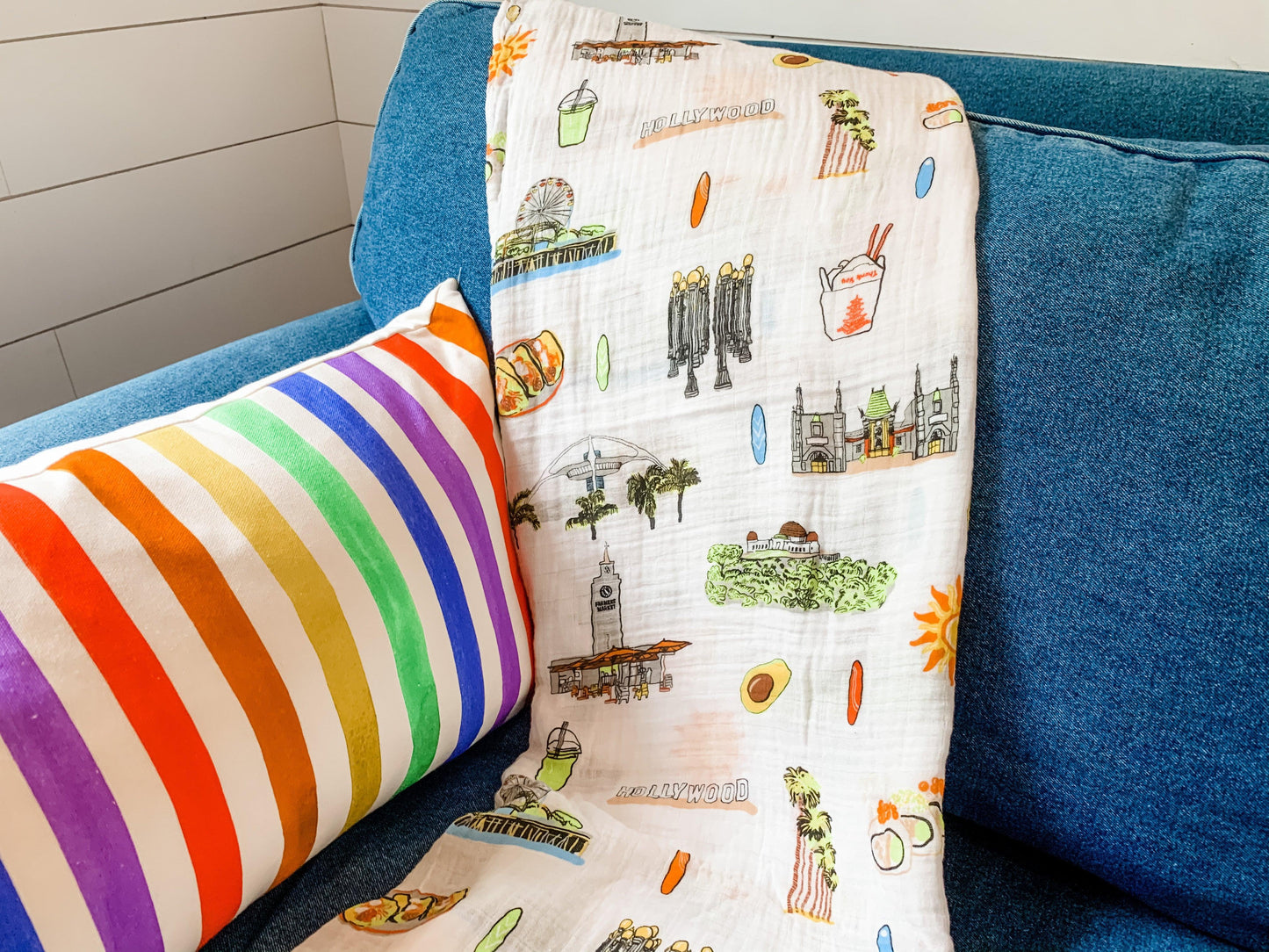 Los Angeles-themed baby muslin swaddle blanket featuring iconic landmarks and pastel illustrations.