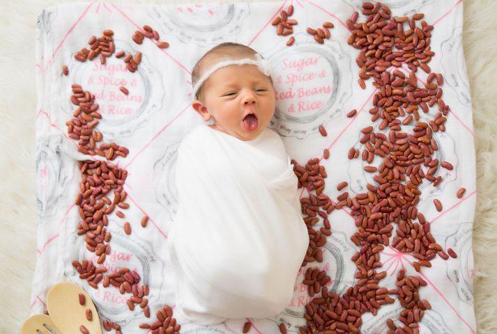 Louisiana-themed baby girl muslin swaddle blanket with pink and white design, featuring state icons and landmarks.