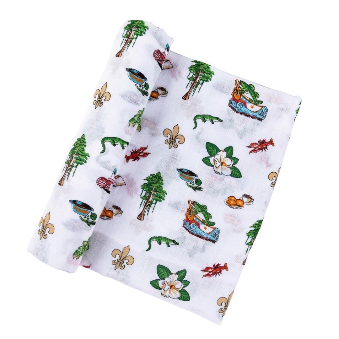 Soft muslin swaddle blanket with Louisiana-themed illustrations, including pelicans, magnolias, and state outline.