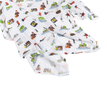 Soft muslin baby swaddle blanket with Austin-themed illustrations, including the Texas Capitol and bats.