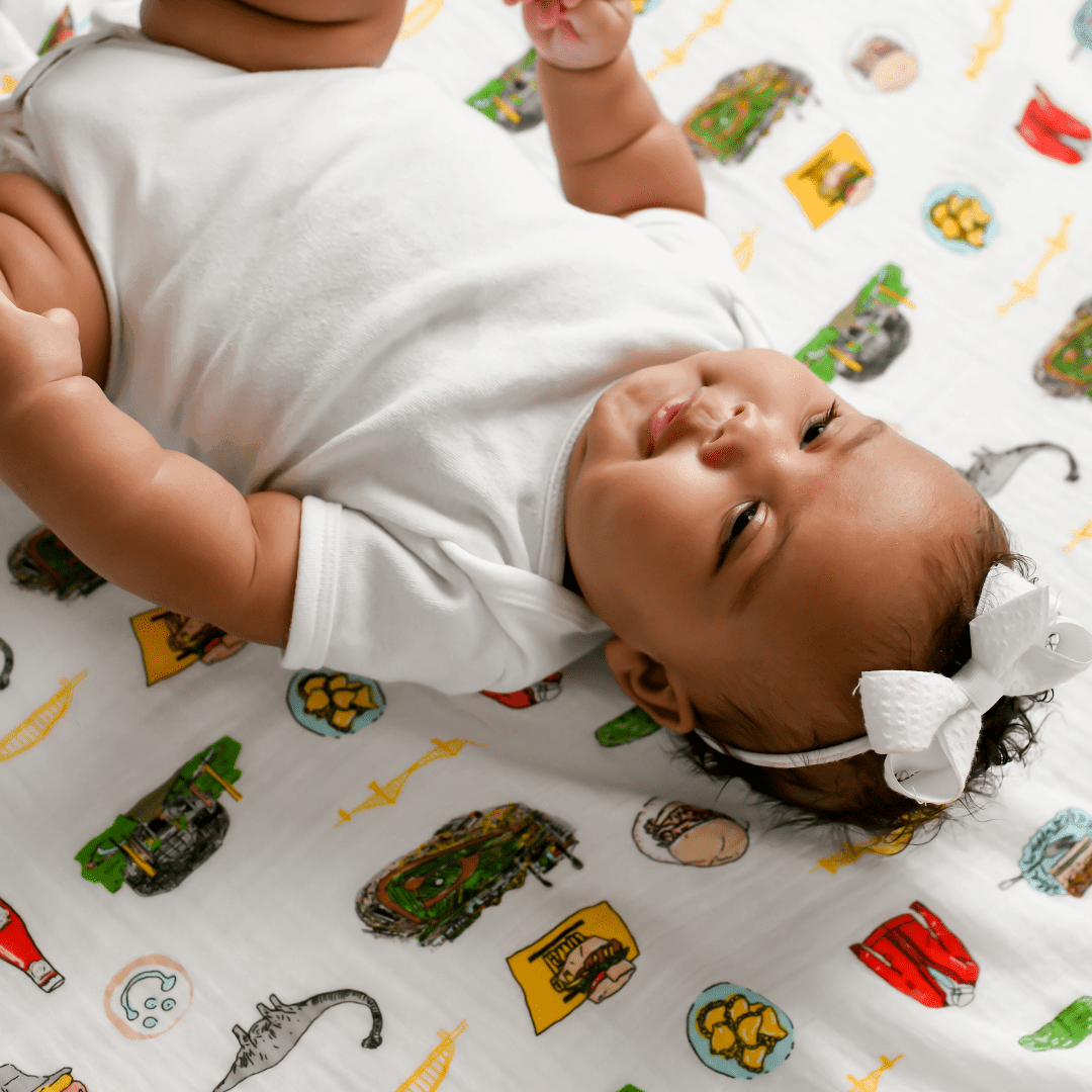 Pittsburgh-themed muslin swaddle blanket featuring iconic city landmarks in a soft, pastel color palette.