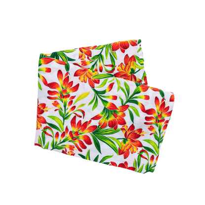 Muslin swaddle baby blanket with a prairie fire design, featuring vibrant red and orange flames on a white background.