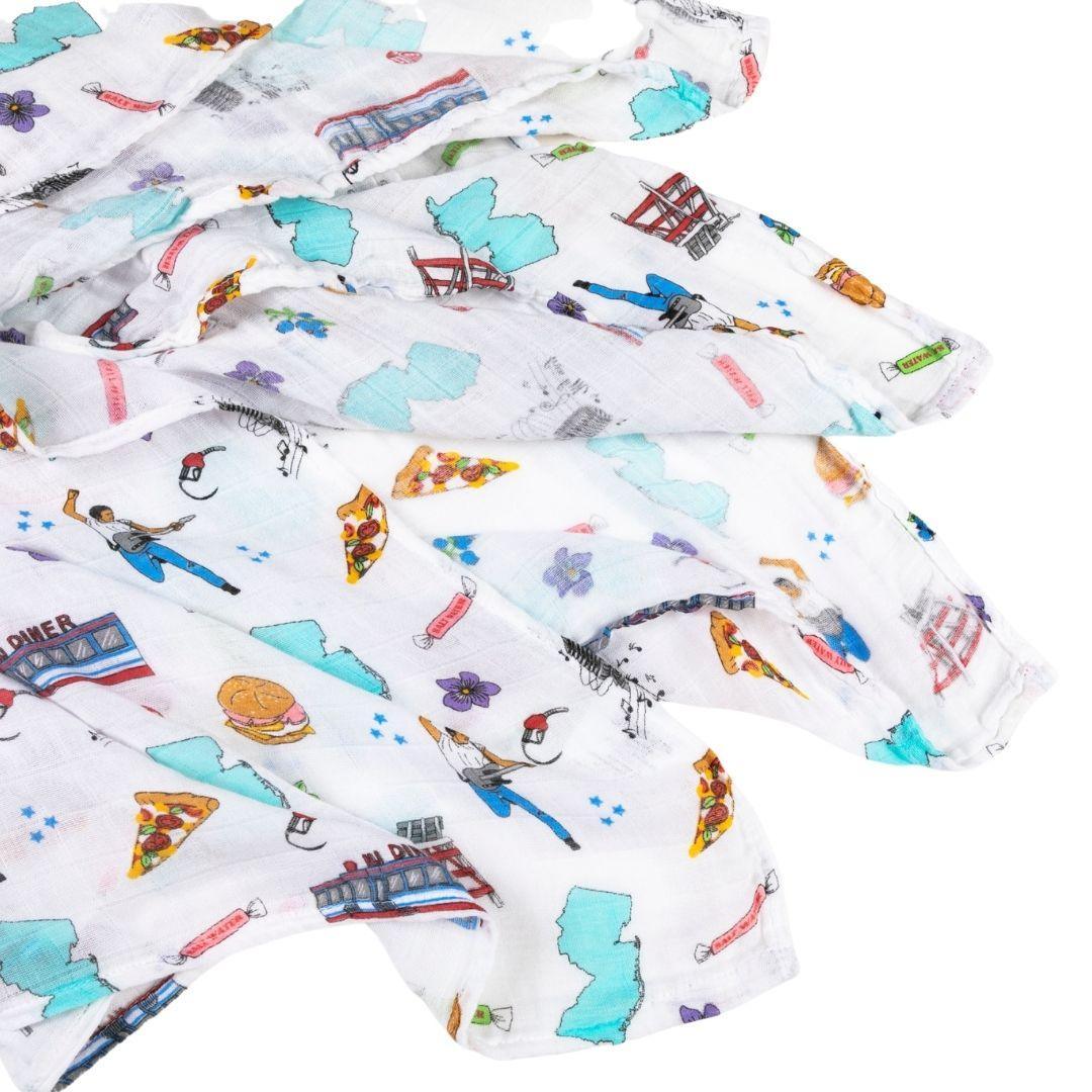 New Jersey-themed baby muslin swaddle blanket with state icons and landmarks in soft pastel colors.