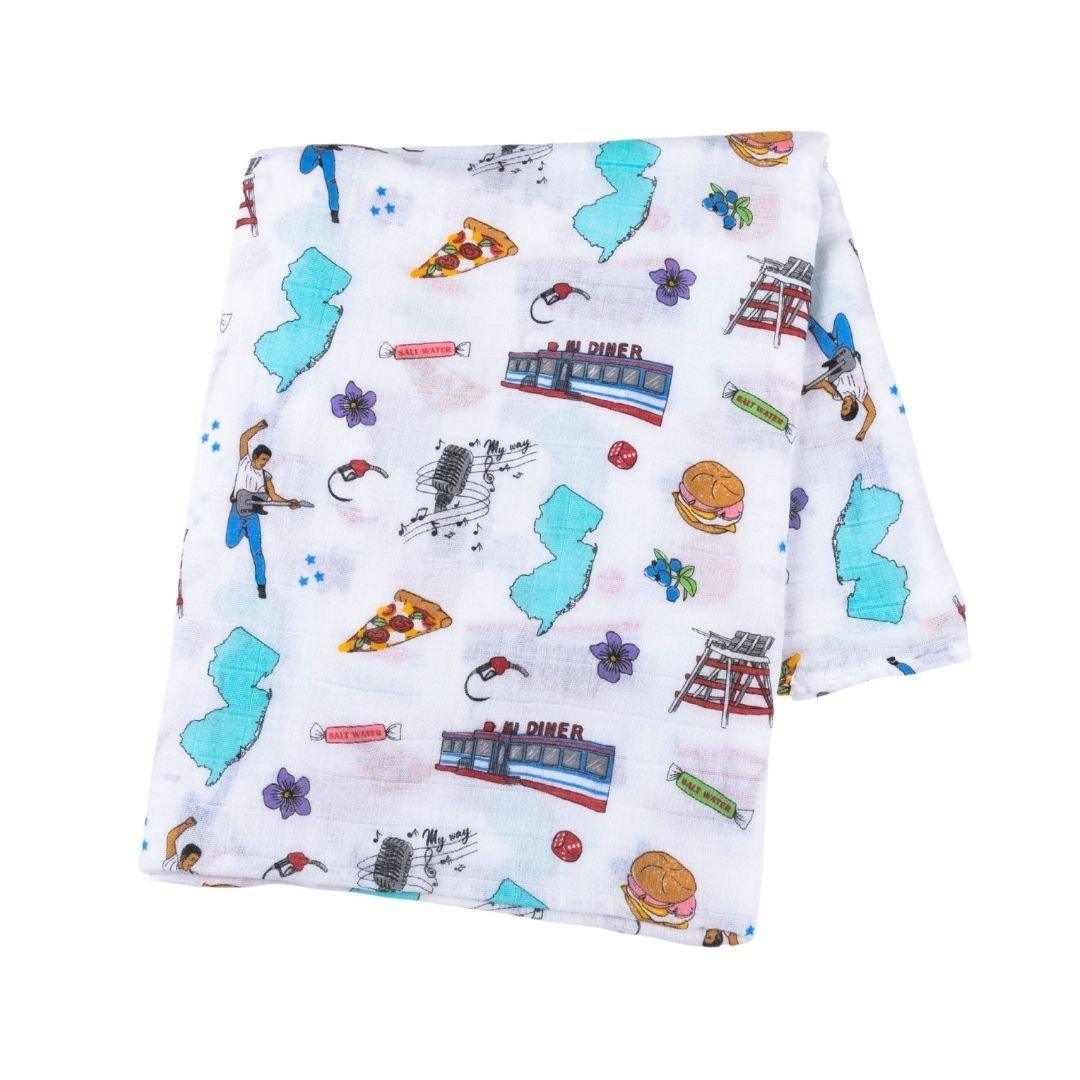 White muslin swaddle blanket with a colorful New Jersey map, featuring landmarks, animals, and state symbols.