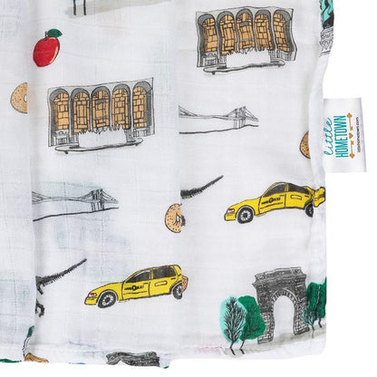 New York City-themed baby muslin swaddle blanket featuring iconic landmarks in soft pastel colors.