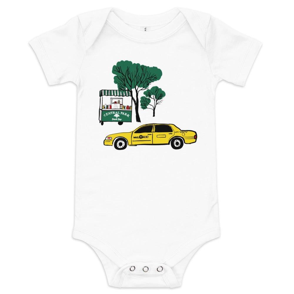 Baby onesie with "Central Park" text on a food cart next to a green tree, and a NYC yellow taxi driving in front of it