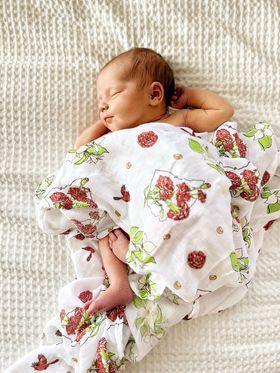 Soft muslin swaddle blanket with delicate floral pattern, featuring "Ohio Baby" text in elegant script.