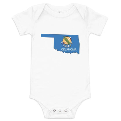 Blue baby onesie with Oklahoma flag design, featuring a shield with a peace pipe and olive branch.