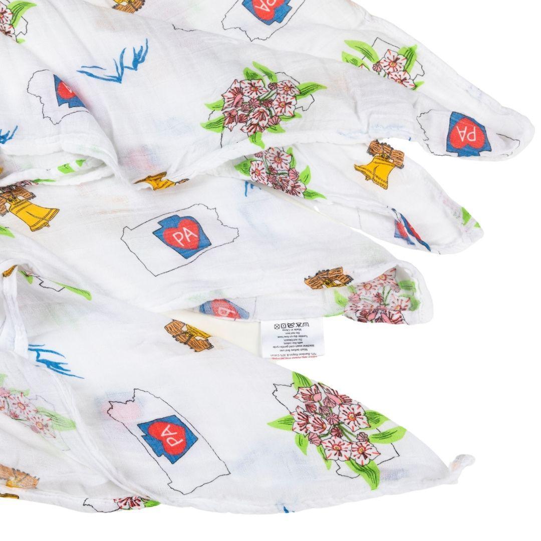 Pennsylvania-themed baby muslin swaddle blanket with state icons like Liberty Bell, deer, and covered bridge.