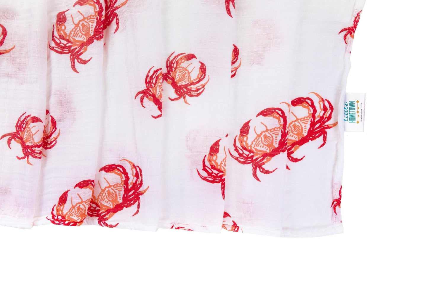 Soft pink muslin swaddle blanket with cute red crab illustrations, perfect for a cozy and adorable baby wrap.