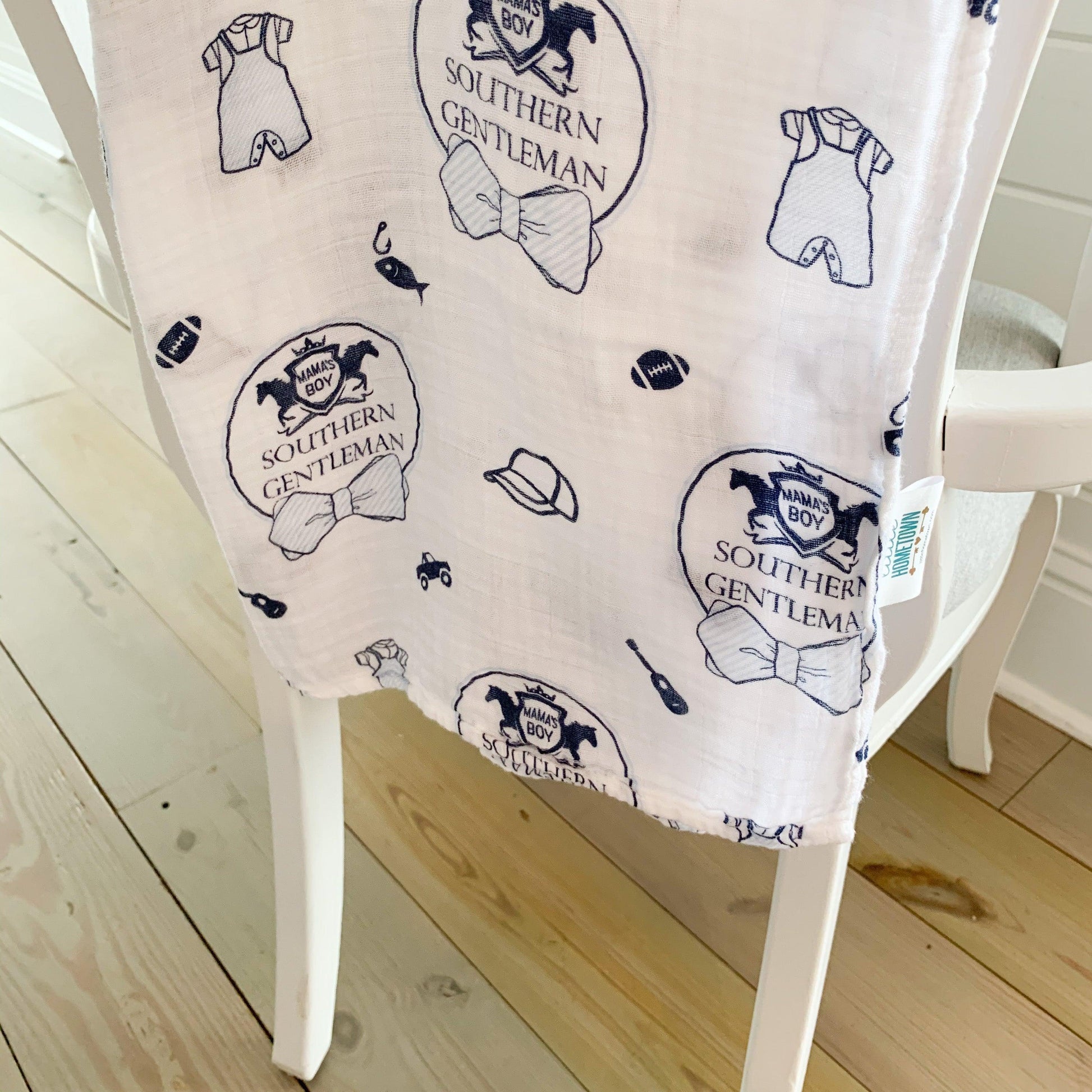 Southern Gentleman baby boy muslin swaddle blanket with blue bow ties and mustaches on a white background.