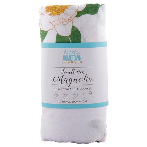 Soft muslin baby swaddle blanket with delicate Southern Magnolia floral print, featuring white and green hues.
