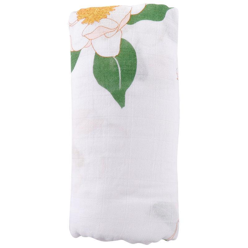 Soft muslin baby swaddle blanket with delicate Southern Magnolia floral print, featuring white and green hues.