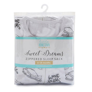 Baby in a white sleep sack with "Sweet Dreams" text, surrounded by pastel stars and moons on a soft blue background.