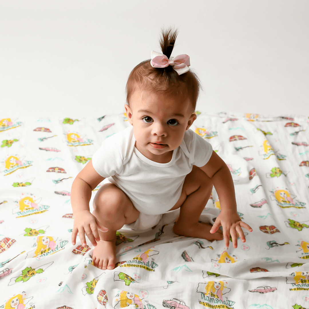 Tennessee-themed baby muslin swaddle blanket with floral design, featuring state symbols and landmarks in pastel colors.