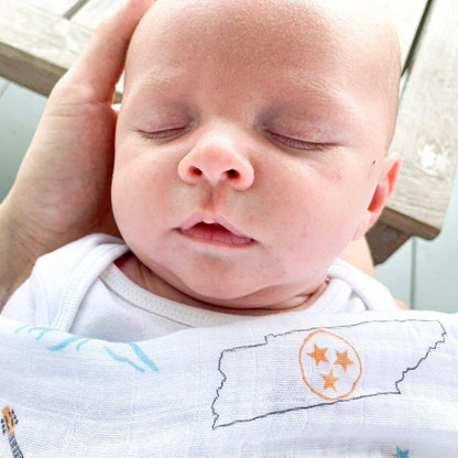 Tennessee-themed baby muslin swaddle blanket with state icons and landmarks in soft pastel colors.