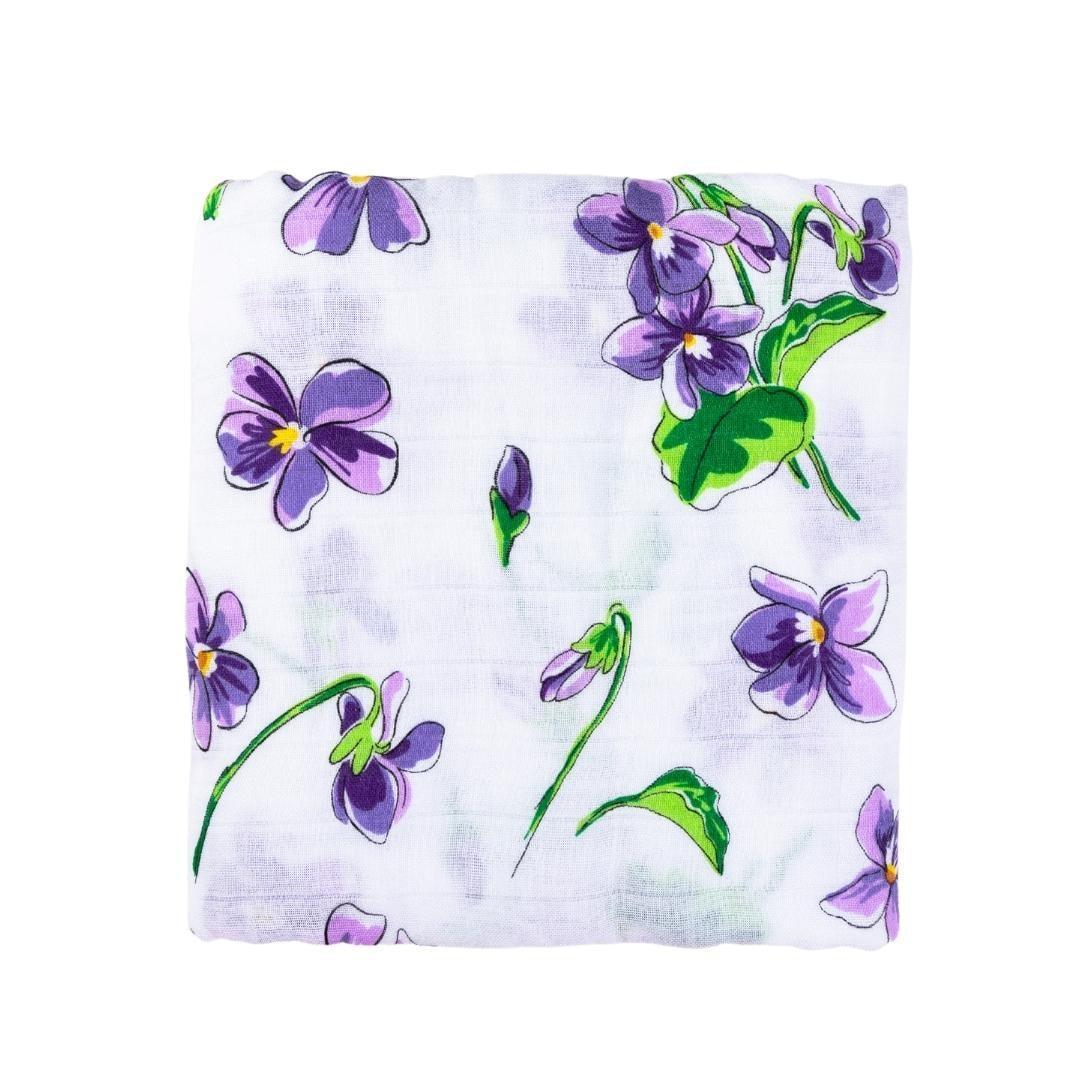 Soft violet muslin swaddle blanket with white floral patterns, neatly folded on a white background.